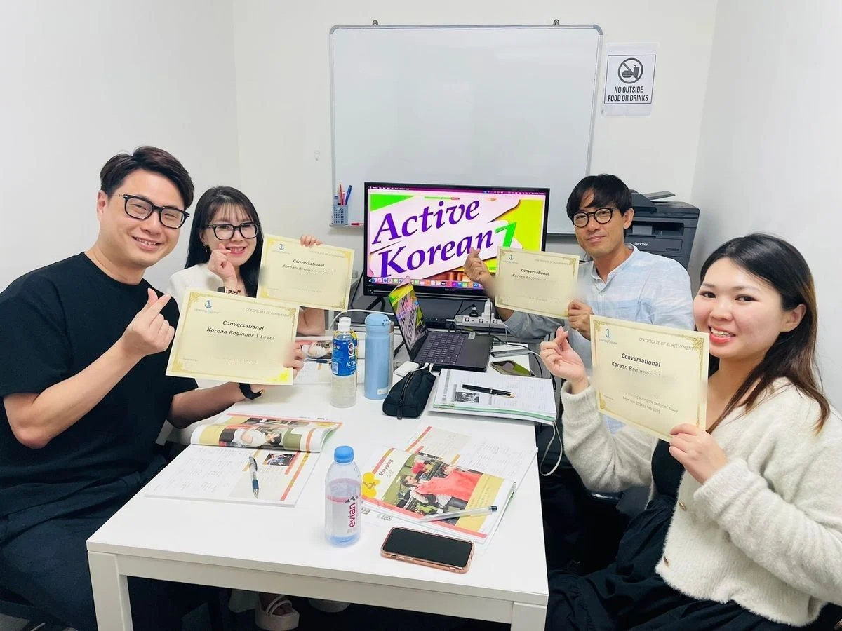 A small group class with their teacher and their Beginner 1 certificates